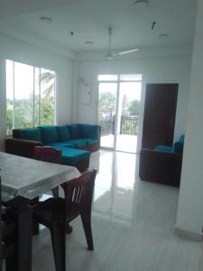 a living room with a blue couch and a table at msm diamond villa in Ragama