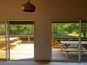 an open door to a deck with a picnic table at Chalet des Épicéas - babyfoot billard & PS in Gérardmer