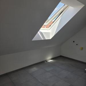 an empty white room with a skylight in the ceiling at schöne Neubau Ferienwohnung "Wiesent" mit Küche und Balkon in Forchheim +1 photo