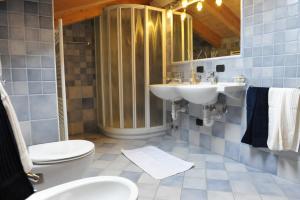 a bathroom with a sink and a toilet and a mirror at Chalet Tea Da Bondi in Livigno +54 photos