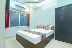 a bedroom with a large bed and a window at FabHotel Taj Palace in kolkata