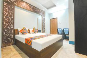 a bedroom with a bed with a large mirror at FabHotel Taj Palace in kolkata