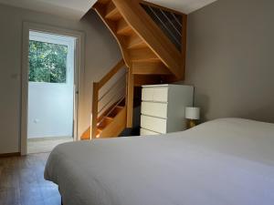 a bedroom with a white bed and a staircase at Chalet des Épicéas - babyfoot billard & PS in Gérardmer +24 photos