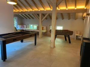 a room with a ping pong table and a pool table at Chalet des Épicéas - babyfoot billard & PS in Gérardmer