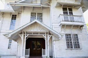 a white house with a wooden door and windows at Hotel Veniz in Baguio