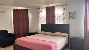 a bedroom with a bed and a chair at The Hideaway Suite, largest master, ocean glimpse in Florence Hall