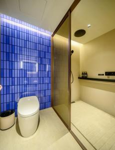 a bathroom with a toilet and a blue tiled wall at Orange Crystal Hotel Kunming Wanda Plaza in Kunming +35 photos
