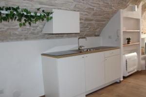 a kitchen with white cabinets and a sink at Suites Anita in Ruvo di Puglia +1 photo