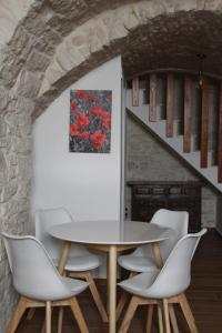a dining room with a table and white chairs at Suites Anita in Ruvo di Puglia