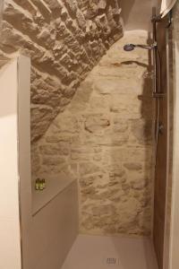 a bathroom with a stone wall at Suites Anita in Ruvo di Puglia