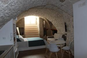 a bedroom with a bed and a table and chairs at Suites Anita in Ruvo di Puglia