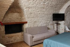 a bedroom with a couch and a brick wall at Suites Anita in Ruvo di Puglia