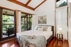 a bedroom with a bed with two towels on it at Hinterland family getaway in Maleny