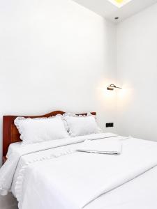 a white bed with white sheets and white pillows at KIGALi WHITE HOMES AND RESIDENCE in Kigali