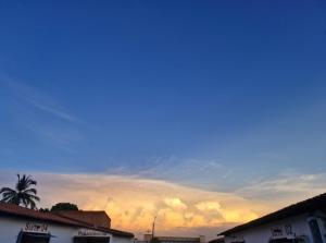 a sunset over a city with buildings and a palm tree at Vamos lá in Caxias das Aldeias Altas