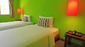 a green room with two beds and a telephone at Baan Supparod in Ko Samed +52 photos