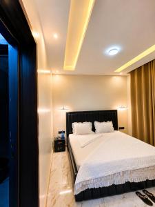 a bedroom with a large bed with white sheets at KIGALi WHITE HOMES AND RESIDENCE in Kigali +12 photos