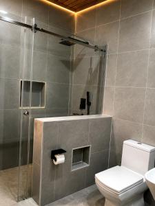 a bathroom with a shower with a toilet and a sink at KIGALi WHITE HOMES AND RESIDENCE in Kigali