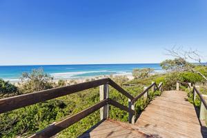a wooden boardwalk leading to the beach at The Art House at Beachside in Yaroomba