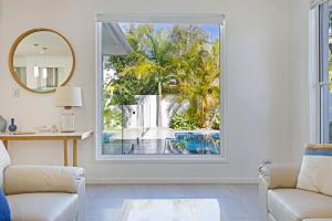 a living room with a window looking out at a pool at The Art House at Beachside in Yaroomba