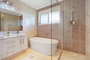a bathroom with a tub and a sink and a shower at The Art House at Beachside in Yaroomba +74 photos