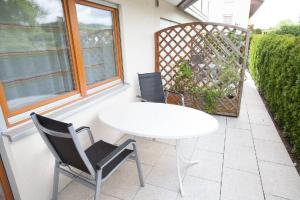 a white table and two chairs on a patio at Gästehaus Schechter in Uhldingen-Mühlhofen +2 photos