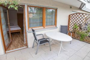 a white table and chairs sitting on a patio at Gästehaus Schechter in Uhldingen-Mühlhofen