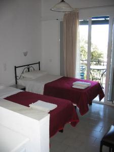 a hotel room with two beds and a balcony at Villa Fiorita in Paleokastritsa
