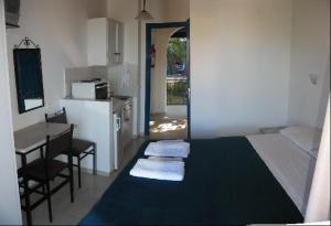 a bedroom with a bed and a table and a kitchen at Villa Fiorita in Paleokastritsa