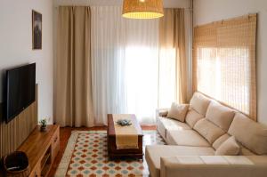 a living room with a couch and a tv at El Riu del Cel in Lloret de Mar