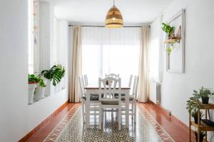 a dining room with a white table and chairs at El Riu del Cel in Lloret de Mar +7 photos