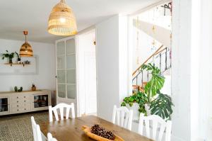 a dining room with a wooden table and white chairs at El Riu del Cel in Lloret de Mar