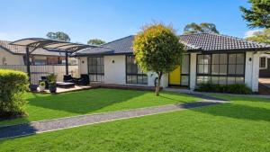 a house with a green lawn in front of it at Stylish 3Bedroom Escape in South Canberra - Hosted by Canstay in Kambah
