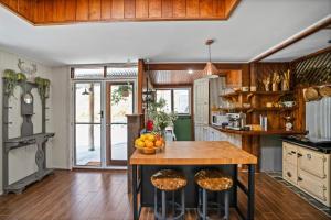 a kitchen with a island with a bowl of fruit on it at Bellbird Rise Off-Grid Cottage in Conondale +79 photos