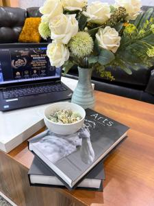 a table with a bowl of food and a vase with flowers at Royal Zam Résidence in Ouagadougou