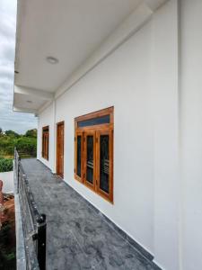 a white house with wooden doors and a walkway at VIN Solara Farm Stay in Jaffna