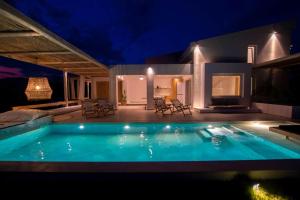 a swimming pool in front of a house at night at Aristotelia Gi - Premium Luxury Villas with Private Pools in Olympiada