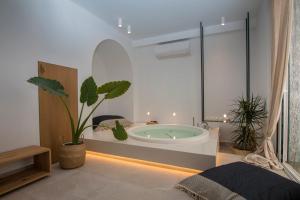 a bathroom with a tub with plants in it at Aristotelia Gi - Premium Luxury Villas with Private Pools in Olympiada