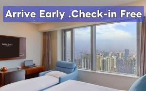 an empty hotel room with a chair and a tv at Novotel Atlantis Shanghai in Shanghai