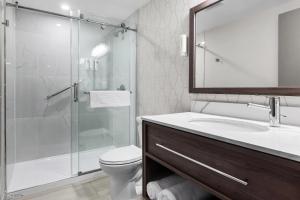 a bathroom with a shower and a toilet and a sink at Comfort Inn in Bracebridge +31 photos