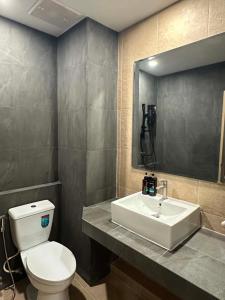 a bathroom with a white toilet and a sink at Tokyo Hotel in Ubon Ratchathani