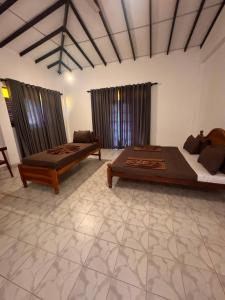 a large room with two beds and a couch at Serendib Villa Mirissa in Mirissa