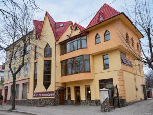 a large yellow building with a red roof at Guest House Asahi in Stryi