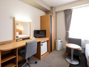 a hotel room with a desk and a bed at Comfort Hotel Shin Yamaguchi in Yamaguchi