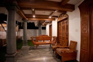 a living room with a table and chairs and a table at Casa de Victoria in Alleppey