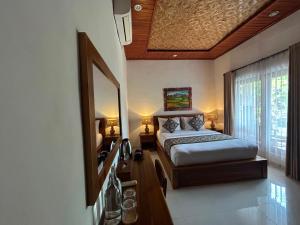 a bedroom with a bed and a large mirror at Raka Rai House in Ubud +7 photos
