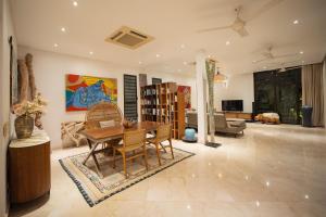 a living room with a wooden table and chairs at Akilea Villas Bali in Uluwatu