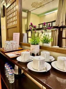 a counter with plates and cups on a table at Park Avenue Boutique Hotel Manila in Manila