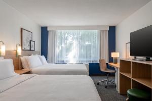 a hotel room with two beds and a television at Spark by Hilton Watertown, NY in Watertown +39 photos