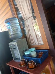 a table with a coffee maker and cups on it at STELAMARIS HomeStay in Pulau Bunaken